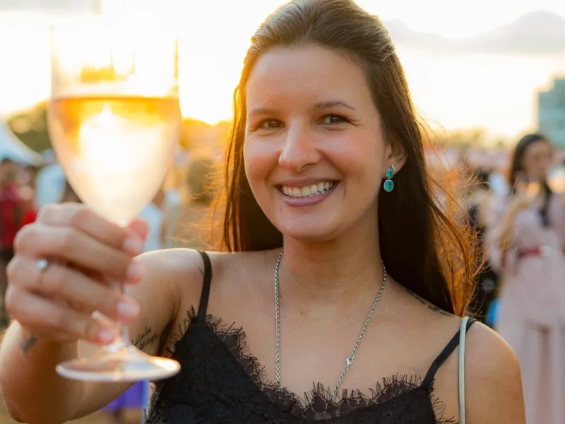 Visitante brindando com uma taça de vinho no festival